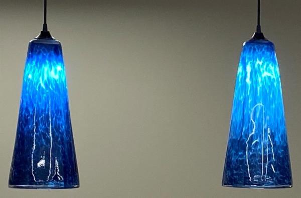 Glass lighting fixtures commissioned by the firm and created with its signature teal color