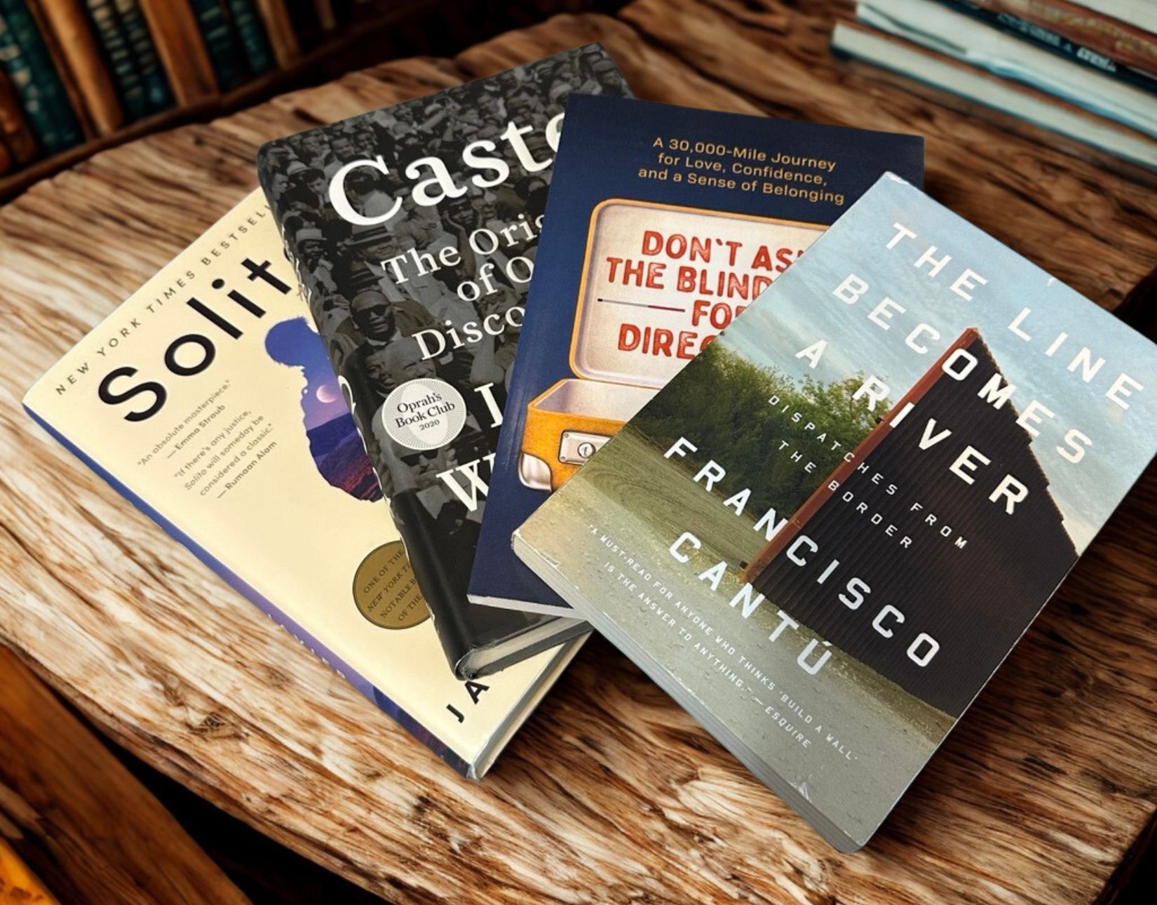 The books, Solito, Caste, Don't Ask the Blind Guy for Directions, and a Line Becomes a River displayed on a table.