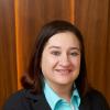 Jodie Bekman wearing a teal shirt and black blazer in formal headshot